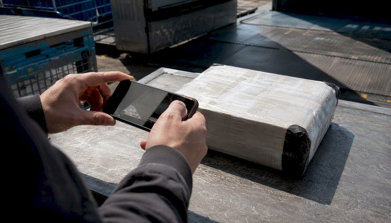 Hands photographing parcel for proof of delivery