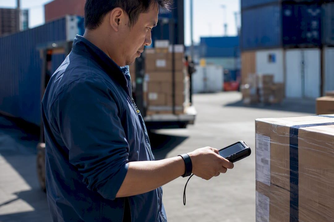Courier scanning parcel barcode at sorting hub