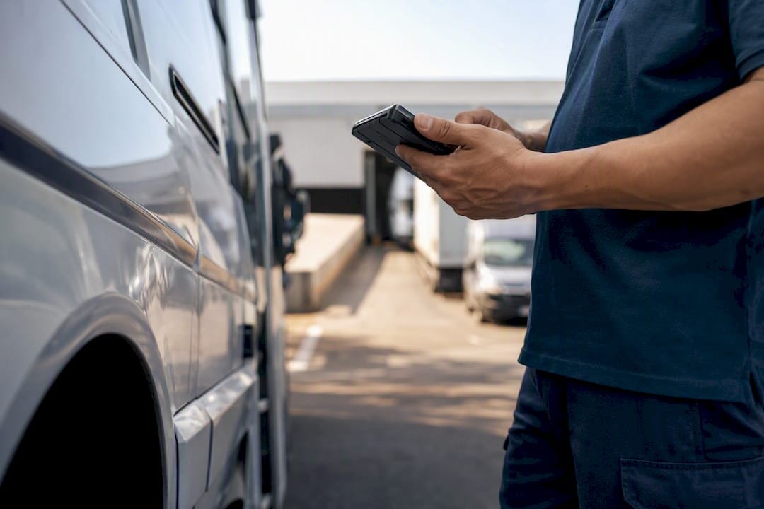 Hands holding device near delivery van